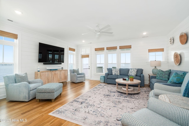 living room with crown molding, wood-type flooring, and ceiling fan