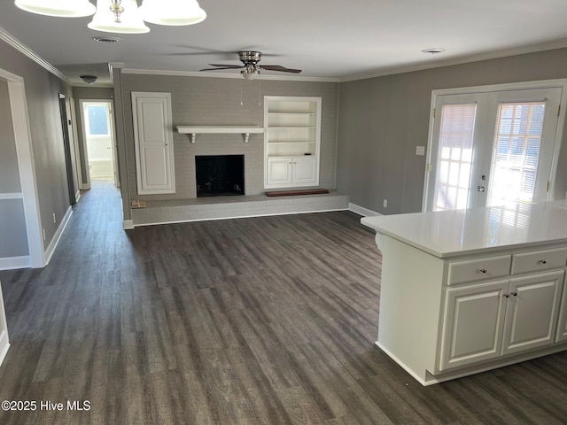 unfurnished living room featuring dark hardwood / wood-style flooring, a fireplace, plenty of natural light, and built in features