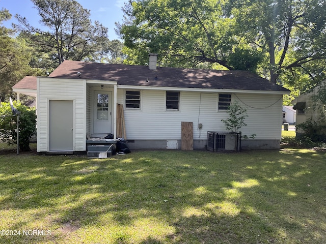 rear view of house featuring a yard and central AC