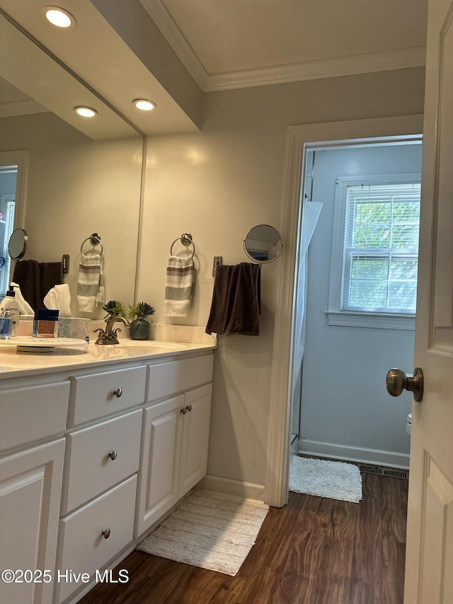 bathroom with hardwood / wood-style floors, vanity, ornamental molding, and walk in shower