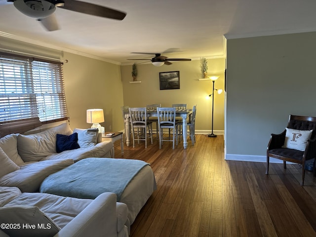 living room with ceiling fan, ornamental molding, and dark wood-type flooring