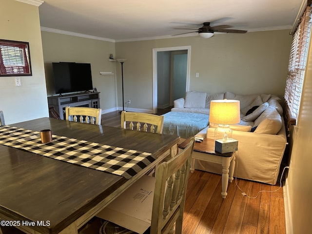 living room featuring crown molding, ceiling fan, and dark wood-type flooring