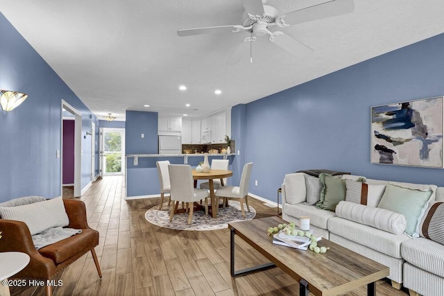 living room featuring light hardwood / wood-style floors and ceiling fan