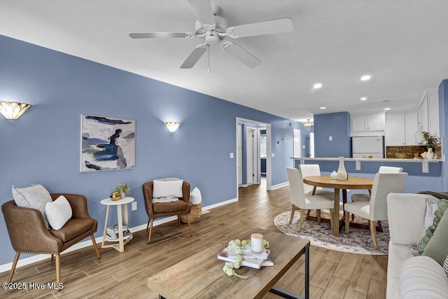 living room with ceiling fan and light wood-type flooring