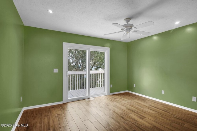 unfurnished room featuring ceiling fan, light hardwood / wood-style flooring, and a textured ceiling