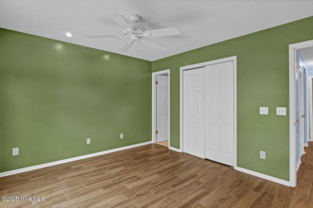 unfurnished bedroom with hardwood / wood-style floors, a closet, and ceiling fan