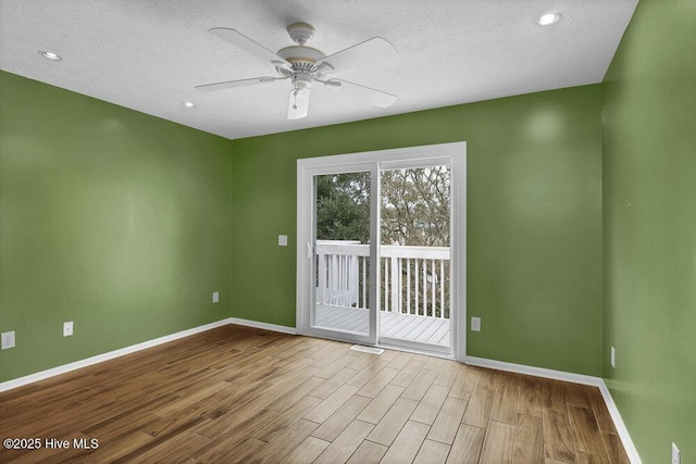 empty room featuring ceiling fan, a textured ceiling, and light wood-type flooring