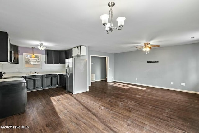 kitchen with appliances with stainless steel finishes, dark hardwood / wood-style flooring, hanging light fixtures, and sink