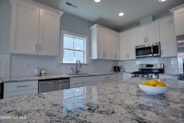 kitchen with stainless steel appliances, white cabinetry, and sink