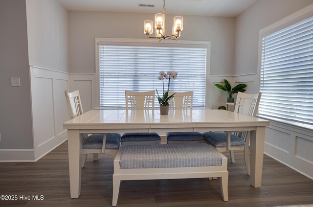 dining area with a notable chandelier and dark wood-type flooring