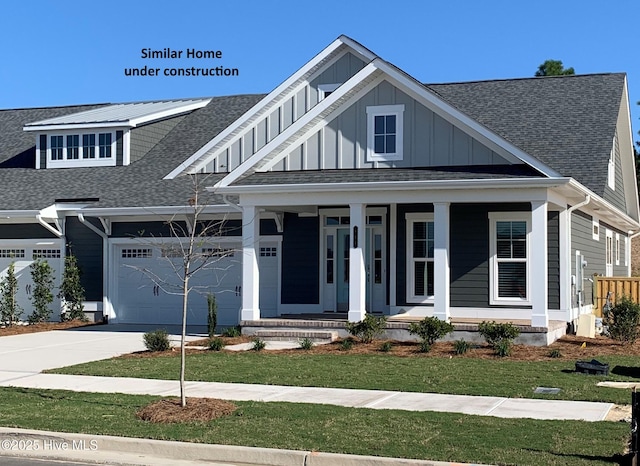 view of front of house with covered porch, a front yard, board and batten siding, driveway, and a shingled roof