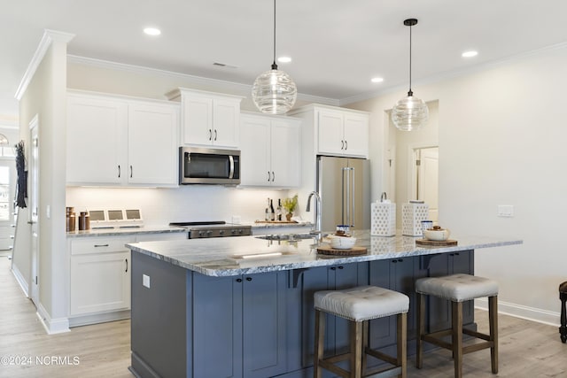 kitchen with pendant lighting, white cabinets, and stainless steel appliances