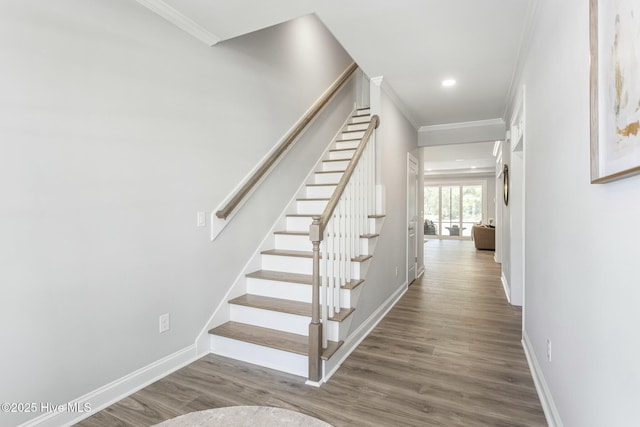 stairway featuring recessed lighting, crown molding, baseboards, and wood finished floors