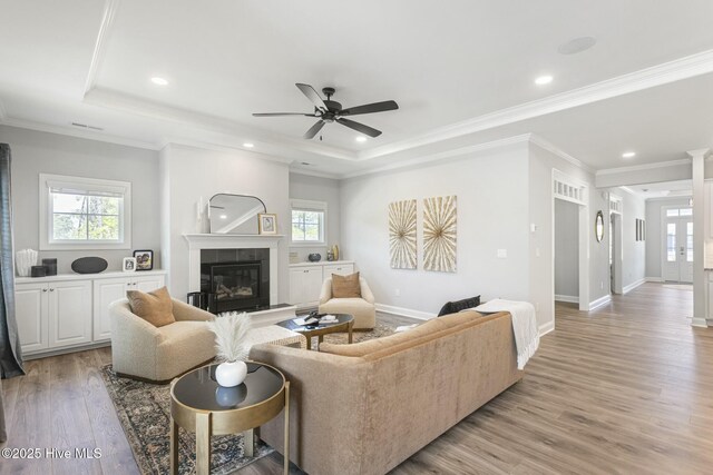 home office featuring light hardwood / wood-style floors, a tray ceiling, and crown molding