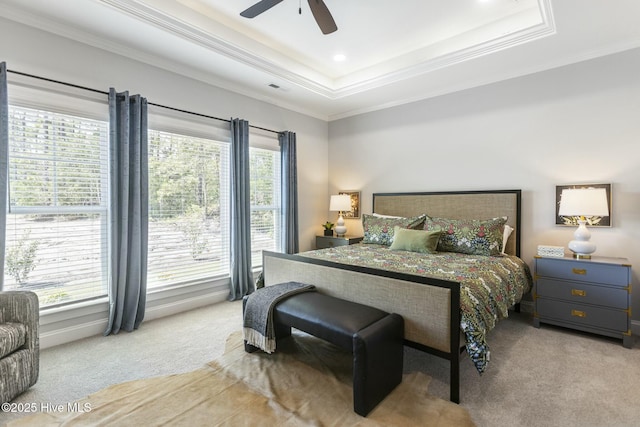 carpeted bedroom with ornamental molding, visible vents, ceiling fan, and a raised ceiling