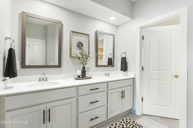 full bath with double vanity, a sink, and tile patterned floors