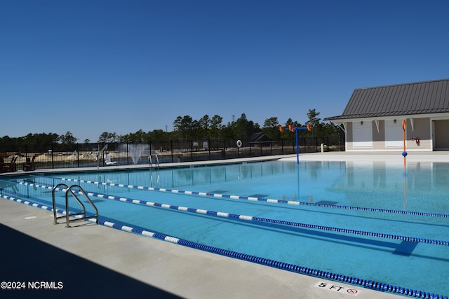 pool with fence and a patio