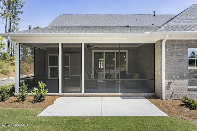 back of house featuring brick siding, a sunroom, a shingled roof, and ceiling fan