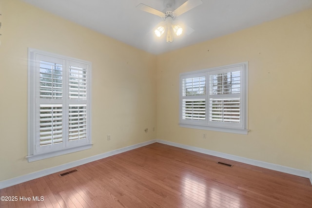 empty room with ceiling fan and hardwood / wood-style floors