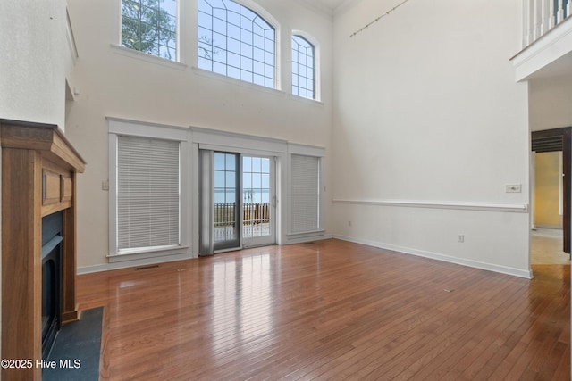 unfurnished living room with a towering ceiling and dark hardwood / wood-style floors