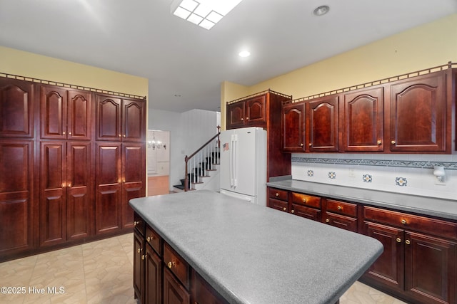 kitchen featuring tasteful backsplash, a kitchen island, and white refrigerator