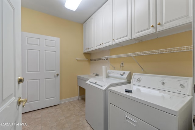 laundry area featuring cabinets, sink, and washing machine and clothes dryer