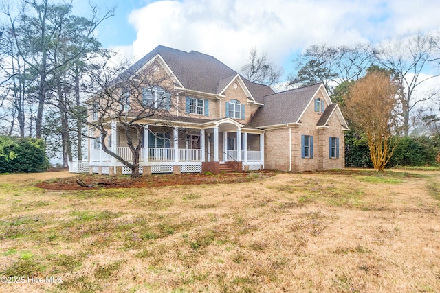 craftsman inspired home featuring covered porch and a front lawn