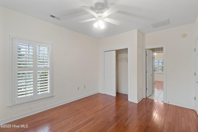 unfurnished bedroom featuring hardwood / wood-style flooring, ceiling fan, and a closet