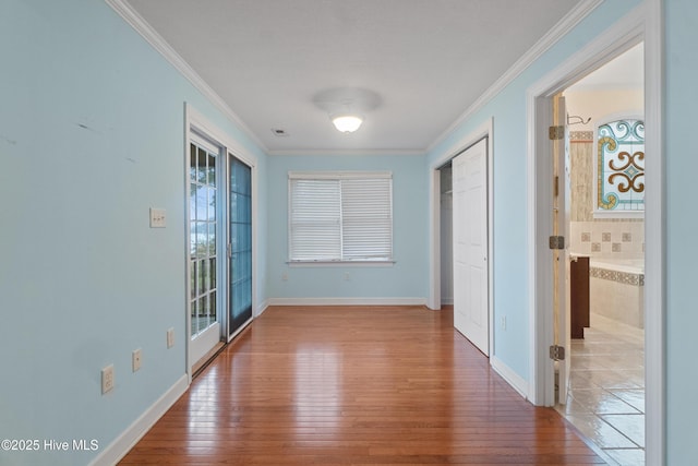 hallway with wood-type flooring and ornamental molding