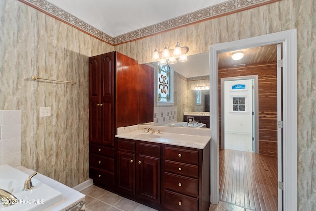 bathroom featuring a tub to relax in, tile patterned flooring, and vanity