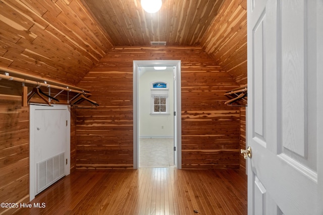 walk in closet with hardwood / wood-style floors and lofted ceiling