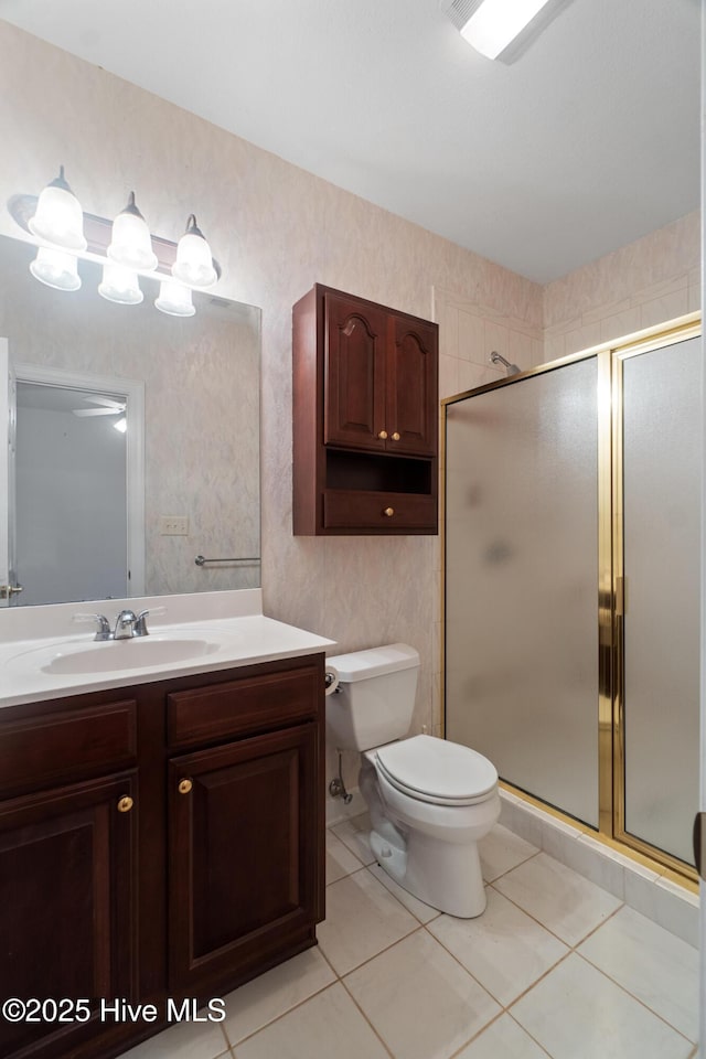 bathroom featuring tile patterned floors, vanity, toilet, and walk in shower