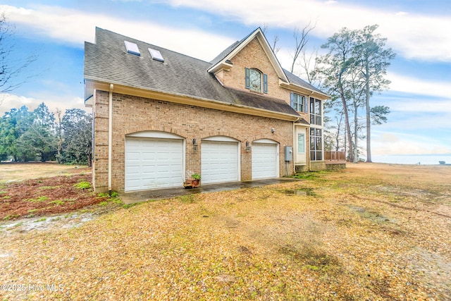 view of side of home featuring a garage and a yard