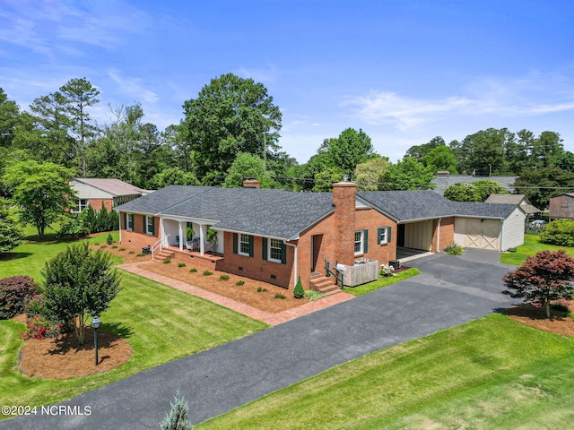 single story home featuring an outbuilding, a front lawn, and a garage