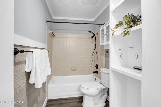 bathroom featuring hardwood / wood-style flooring, tiled shower / bath combo, and toilet