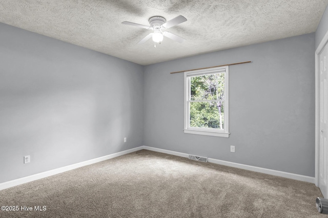 carpeted empty room featuring ceiling fan and a textured ceiling