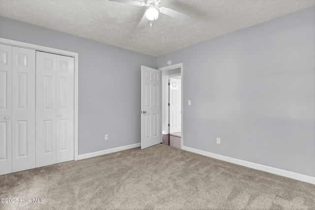 unfurnished bedroom featuring ceiling fan, a closet, carpet floors, and a textured ceiling