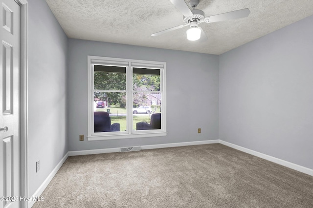 unfurnished room with ceiling fan, carpet, and a textured ceiling