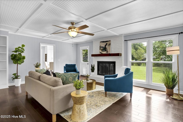 living room featuring plenty of natural light, dark hardwood / wood-style flooring, a fireplace, and coffered ceiling