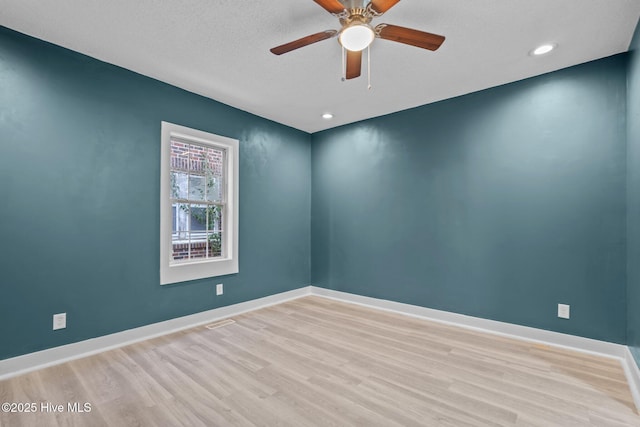 unfurnished room featuring a textured ceiling, light hardwood / wood-style floors, and ceiling fan