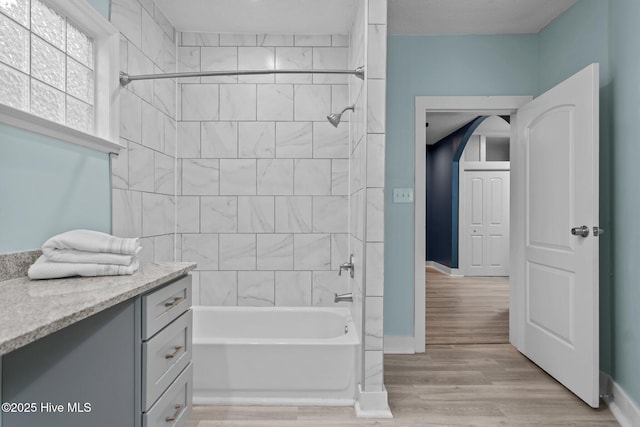 bathroom with vanity, tiled shower / bath combo, and wood-type flooring