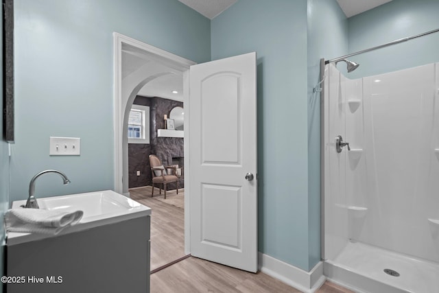 bathroom featuring vanity, wood-type flooring, a textured ceiling, and walk in shower