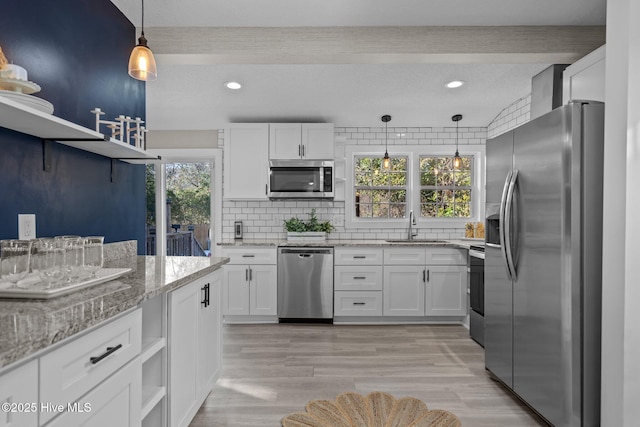 kitchen featuring sink, tasteful backsplash, decorative light fixtures, appliances with stainless steel finishes, and white cabinets