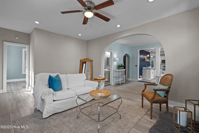 living room with wood-type flooring and ceiling fan