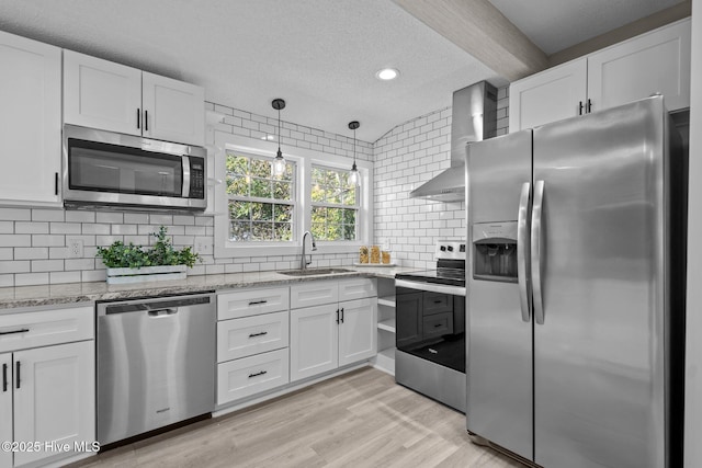 kitchen featuring stainless steel appliances, sink, white cabinets, and wall chimney exhaust hood