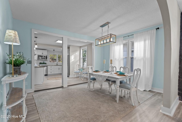 dining space with light hardwood / wood-style flooring and a textured ceiling