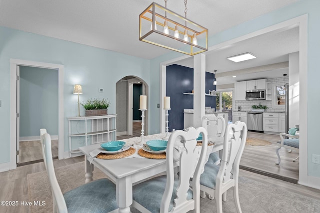 dining room with an inviting chandelier and light hardwood / wood-style flooring