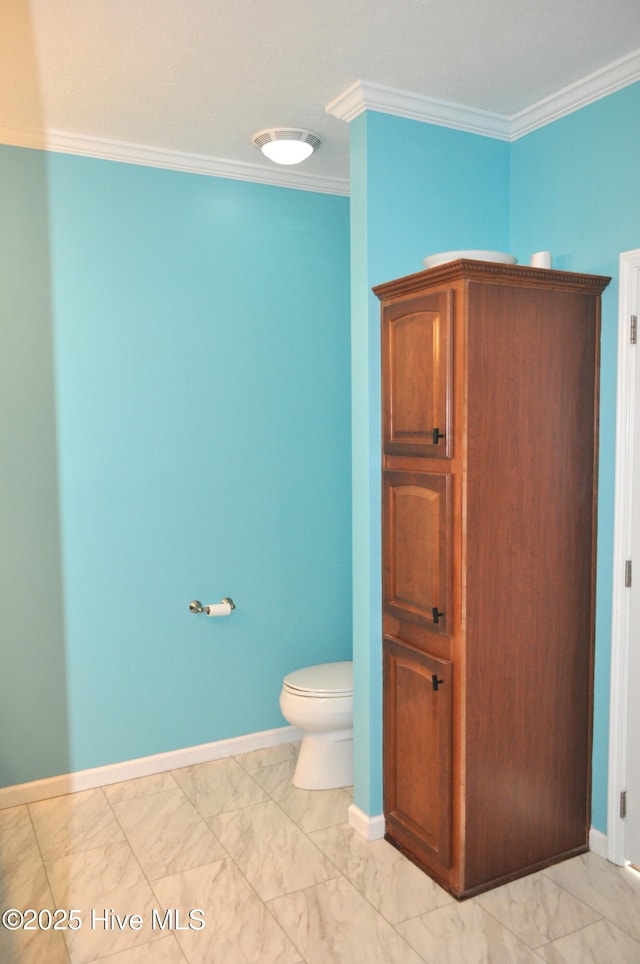 bathroom with crown molding and toilet