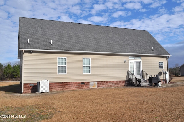 back of property featuring a yard and central AC