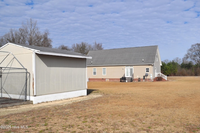 view of side of property with a yard and a storage unit